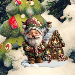 Detail of Christmas garden gnome standing by a snowy miniature house with festive lights
