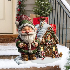 Detail of Christmas gnome figurine and snow-covered gingerbread house on outdoor steps