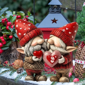 Christmas gnome garden stakes with heart patterns in a snowy outdoor winter landscape