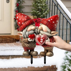 Detail of Christmas gnome garden stakes with red heart motifs for outdoor holiday decor