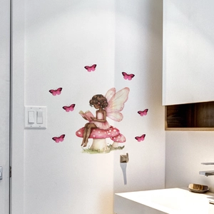 Dettaglio di un adesivo murale con fata su fungo e farfalle rosa in un angolo della stanza