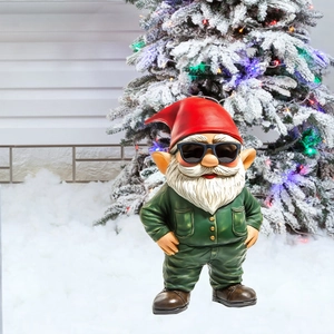Detail of Christmas gnome garden stake with sunglasses and red hat on snowy background