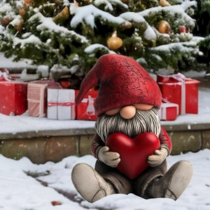 Christmas gnome garden stake with red hat and heart on a snowy holiday background