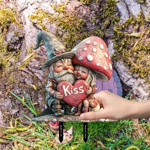 Garden gnome decoration featuring two gnomes hugging a red heart with Kiss text