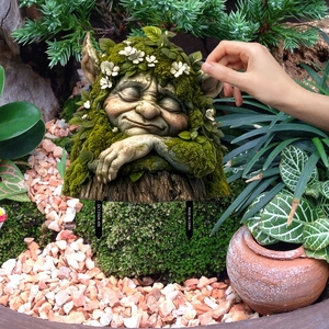 Garden root elf decoration stake with realistic moss and white flowers on a stump