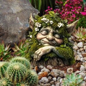 Detailed view of garden gnome statue with green faux moss and flowers in outdoor planter