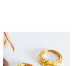 Detailed view of two gold croissant twist rings in a vintage minimalist aesthetic style