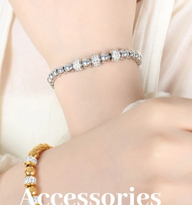 Détail d'un bracelet de perles avec billes métalliques polies et cylindres en strass