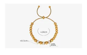 Détail du bracelet ajustable en perles dorées avec des entretoises serties de strass