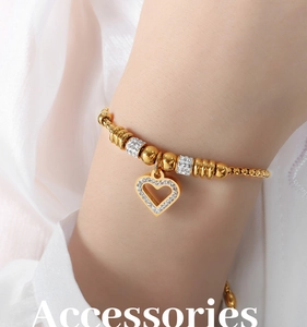 Detail of heart pendant bracelet in gold with white diamonds on model wrist