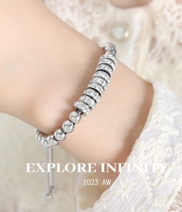 Détail du bracelet à perles argentées avec strass brillants et cordon réglable