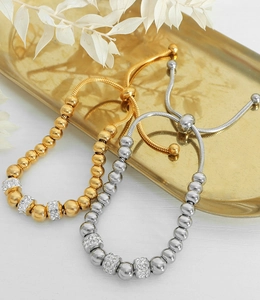 Gros plan de bracelets perlés réglables en or et argent avec des diamants pavés brillants