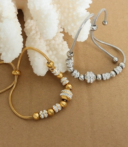Macro detail of adjustable gold and silver snake chains with crystal-encrusted beads