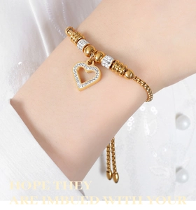 Detail of adjustable gold heart bracelet with sparkling zircon stones on a model wrist