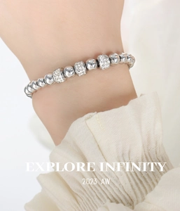 Gros plan d'un bracelet à perles argentées avec des charmes en strass brillants au poignet