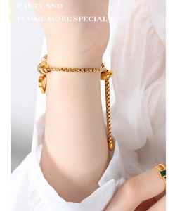 Detail of adjustable gold box chain bracelet with heart charm and slider bead