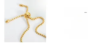 Detail of adjustable gold slide clasp and fine box chain on a stainless steel bracelet