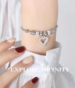 Close-up of titanium steel beaded bracelet with diamond heart pendant on wrist
