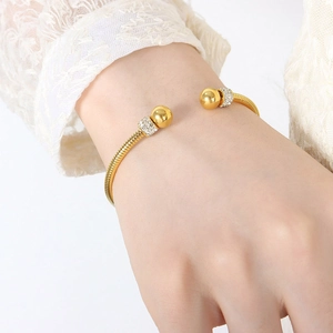 Elegant gold plated stainless steel open bangle with crystal pavé beads on a wrist