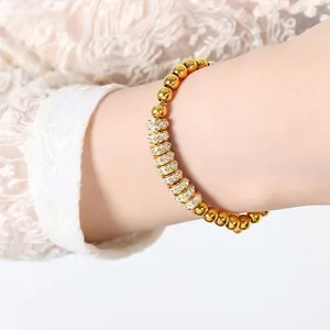 Bracelet à billes plaqué or élégant avec anneaux sertis de strass sur un poignet féminin