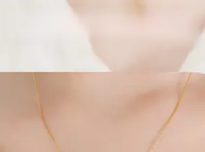 Close-up of golden stainless steel bunny necklace chain worn on a female neck