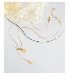 Detail of gold rabbit and carrot pendants on a fine snake chain necklace for women