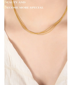 Close-up of elegant multi-layer 18K gold plated chain necklace on a model