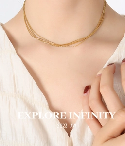 Close-up of elegant layered 18K gold-plated choker chains on model with white top