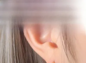 Detailed close-up of 18K gold-plated irregular C-shape earring worn on the earlobe