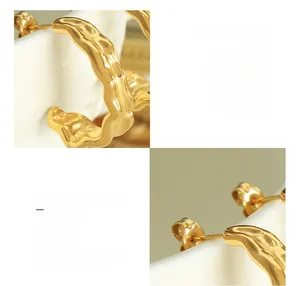 Macro detail of 18K gold plated titanium steel hoop earrings with textured wavy design