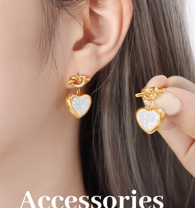 Detailed view of heart-shaped earrings with micro-set zircons on a golden knot studs