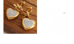 Macro detail of gold-plated knot earrings with heart-shaped pave zirconia settings