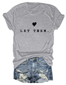 Detail of grey Let Them t-shirt with heart print and distressed blue denim shorts
