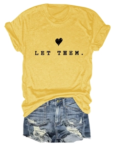 Detail of yellow Let Them t-shirt paired with distressed blue denim shorts