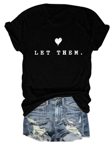 Close-up of Let Them printed black t-shirt paired with distressed denim shorts