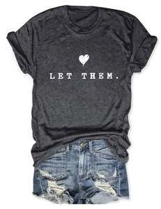 Close-up of dark grey t-shirt with LET THEM print and distressed denim shorts details