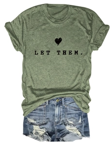 Flat lay of olive green cotton T-shirt with 'LET THEM.' print and distressed denim shorts