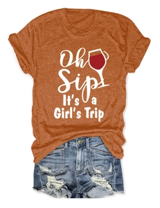 Dettaglio della stampa Oh Sip It's a Girl's Trip su T-shirt arancione con shorts di jeans