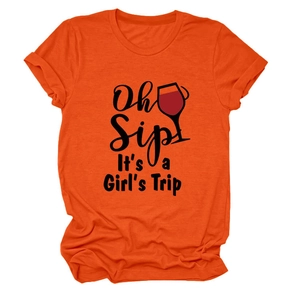 Dettaglio della stampa 'Oh Sip It's a Girl's Trip' su una maglietta in cotone arancione
