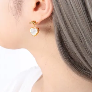 Exquisite gold knot heart earrings with micro-set rhinestones shown on model