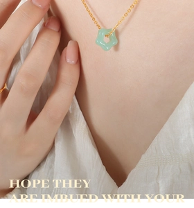 Détail du pendentif fleur en jade étoilé sur une chaîne de clavicule dorée élégante