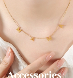 Détail du collier avec pendentif MAMA plaqué or porté sur une chemise blanche chic