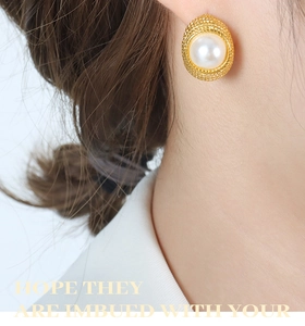 Macro side view of vintage French pearl earring with textured gold base on model