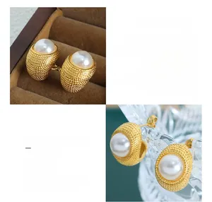 Macro detail of French vintage C-shape gold titanium earring with a large pearl inlay
