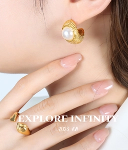 Detail of vintage French style gold plated pearl earrings and heart shape open ring on model
