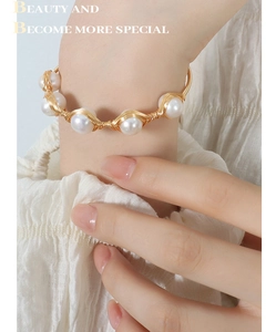 Detail of handmade gold brass wire wrapped around white Baroque freshwater pearls bracelet