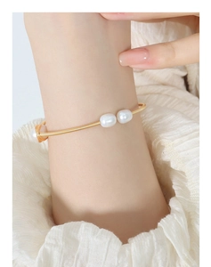 Detailed view of handmade brass gold wire cuff bracelet with white freshwater pearls