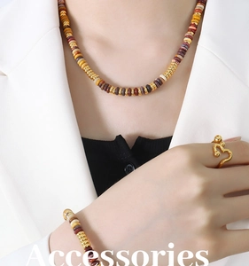 Detail of beaded gemstone necklace and bracelet set with modern gold wave ring on model