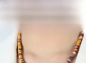 Close-up of ethnic style necklace with multi-color natural stone beads and gold accents