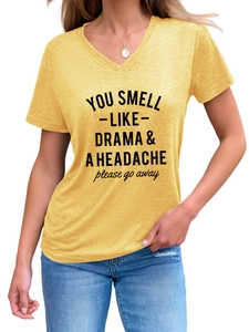 Detail eines gelben V-Ausschnitt T-Shirts mit You Smell Like Drama Slogan-Aufdruck